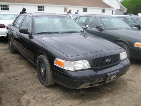 1991 Ford LTD Crown Victoria - A black Ford Crown Victoria Police Interceptor is parked in front of a building with other vehicles nearby.