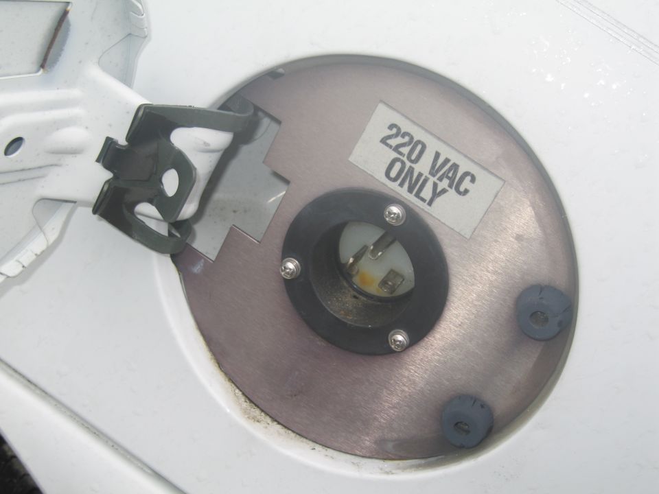 Fuel filler door open showing a 220 VAC electrical outlet and "220 VAC ONLY" sticker