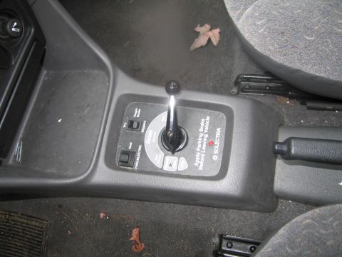 1991 Ford LTD Crown Victoria - Interior view of a car's center console, showing the gear shifter and a control panel.