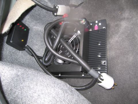 1991 Ford LTD Crown Victoria - Aftermarket electronic module with fan and indicator lights, installed in vehicle carpet.