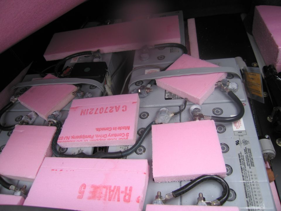 Multiple batteries with pink foam padding and wires connected