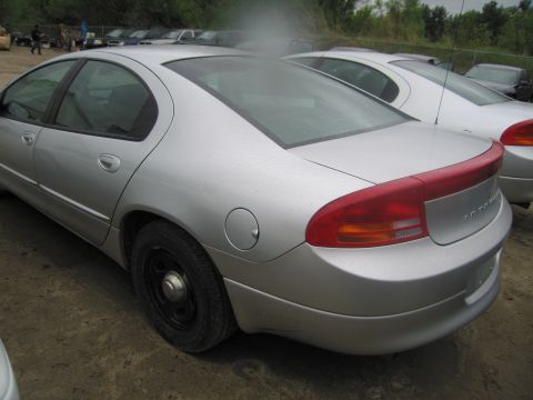 1991 Ford LTD Crown Victoria - A silver sedan is parked outdoors, showing its rear end with a red accent on the taillight bar and a spoiler.
