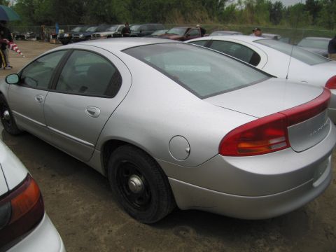 1991 Ford LTD Crown Victoria - Silver sedan with red taillight trim parked in an outdoor lot with other vehicles.