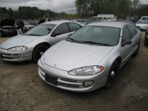 1991 Ford LTD Crown Victoria - Two silver sedans are parked side-by-side on a dirt lot under an overcast sky.