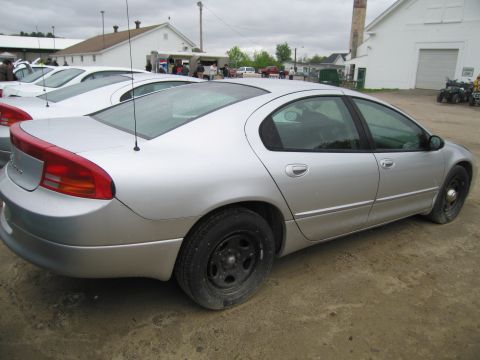 1991 Ford LTD Crown Victoria - A silver sedan is parked outdoors next to other vehicles under an overcast sky.
