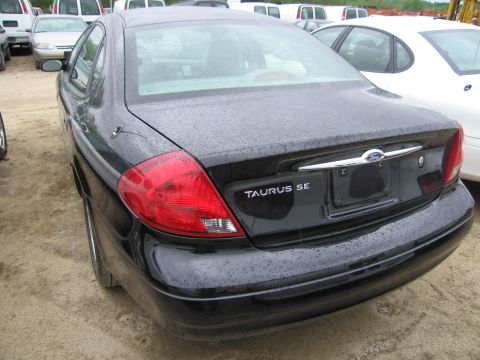 1991 Ford LTD Crown Victoria - The rear of a black Ford Taurus SE is shown in an outdoor lot with other vehicles.