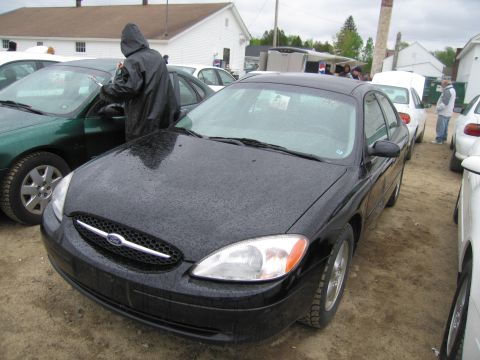 1991 Ford LTD Crown Victoria - A black Ford sedan is parked in an outdoor lot with other vehicles.