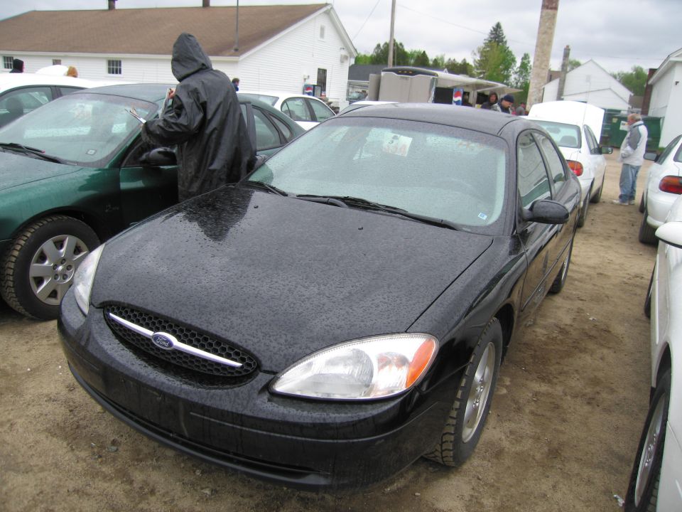 Black Ford sedan, front 3/4 view, parked outdoors