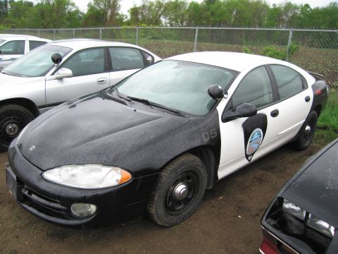 1991 Ford LTD Crown Victoria - A black and white police car is parked outdoors next to another vehicle.