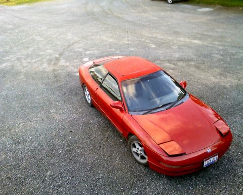 1993 Ford Probe - This red 1993 Ford Probe is seen from a high angle, parked on a gravel surface.