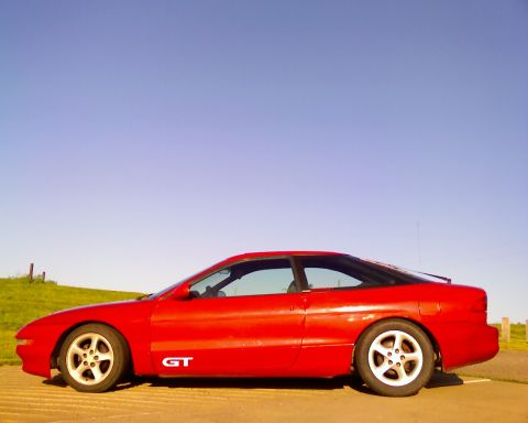 1993 Ford Probe - A red 1993 Ford Probe GT is parked on a sunny day with a clear blue sky.