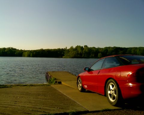 1993 Ford Probe - Red 1993 Ford Probe GT sits on a boat ramp with a lake and trees in the background.