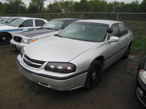 1991 Ford LTD Crown Victoria - A silver sedan, possibly a police vehicle, is parked outdoors on a dirt lot.