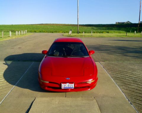 1993 Ford Probe - A red 1993 Ford Probe is parked outdoors on a sunny day, facing the camera.