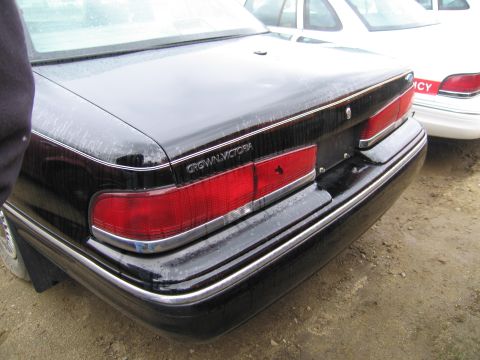 1991 Ford LTD Crown Victoria - Rear view of a black 1991 Ford Crown Victoria LTD sedan, showing its distinctive taillights and chrome accents.