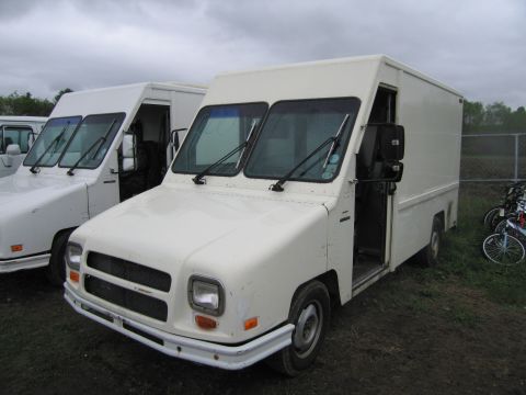 1991 Ford LTD Crown Victoria - Two white step vans are parked side-by-side in an outdoor lot.