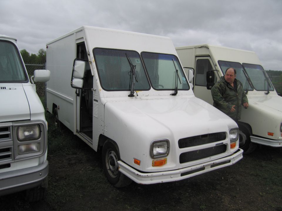 White step van with driver's door open, parked next to another step van