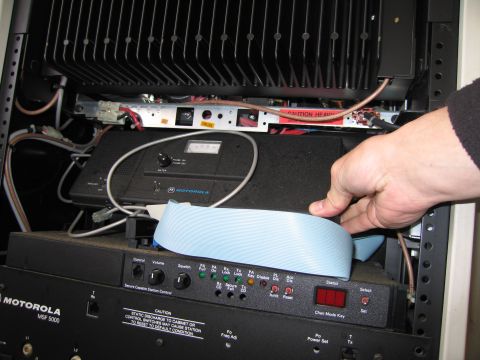 1991 Ford LTD Crown Victoria - A hand manipulates a blue ribbon cable connected to electronic equipment within a rack.