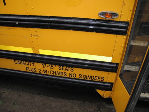 1991 Ford LTD Crown Victoria - Photo of a yellow school bus exterior with painted seating-capacity lettering, not a technical document.