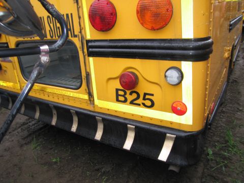 1991 Ford LTD Crown Victoria - Rear view of a yellow school bus showing its bumper and lights, with B25 designation.