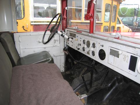 1991 Ford LTD Crown Victoria - The interior of a bus shows the driver's seat, steering wheel, and dashboard with various gauges and controls.