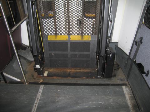 1991 Ford LTD Crown Victoria - Interior of a vehicle showing a wheelchair lift platform and mechanism.