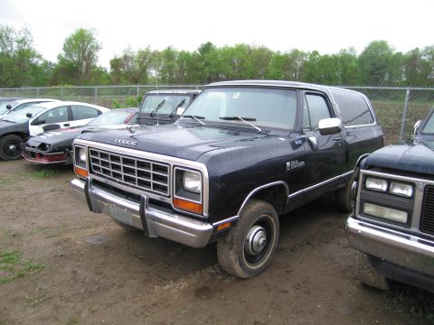 1991 Ford LTD Crown Victoria - Dark blue Dodge Ramcharger SUV parked outdoors with other vehicles in the background.