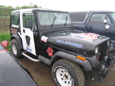1991 Ford LTD Crown Victoria - A black and white Jeep Wrangler is parked next to another vehicle.
