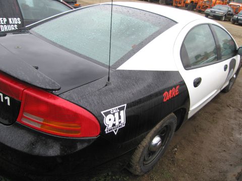 1991 Ford LTD Crown Victoria - Police car with DARE and 911 decals, parked next to another vehicle.