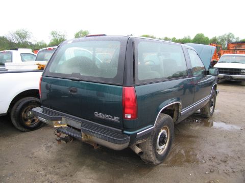 1991 Ford LTD Crown Victoria - This green Chevrolet SUV is seen from the rear, with "CHEVROLET" badging clearly visible on the tailgate.