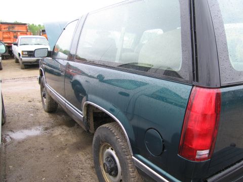 1991 Ford LTD Crown Victoria - A green SUV is parked next to a white pickup truck, with the SUV's hood open.