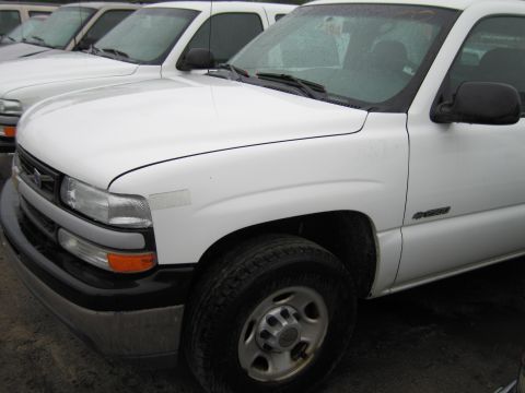 1991 Ford LTD Crown Victoria - A white pickup truck is parked in a lot with several other vehicles visible in the background.