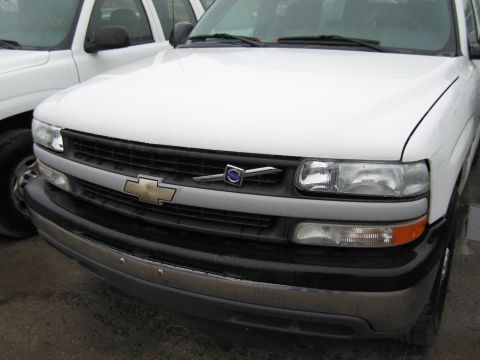 1991 Ford LTD Crown Victoria - Front view of a white Chevrolet pickup truck, showing the grille and headlights. Another vehicle is parked nearby.