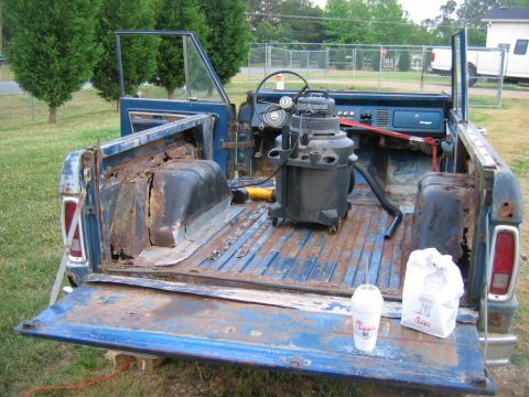 1992 Ford Mustang - This 1974 Ford Bronco is in a state of disrepair, with significant rust visible in the bed and interior. A shop vac and fast food bag sit i…