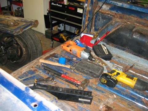 1992 Ford Mustang - Tools are laid out in the bed of a rusty blue pickup truck, ready for a project.