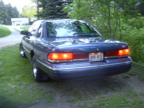 1996 Ford Crown Victoria - Rear view of a blue sedan with chrome accents and a license plate visible.