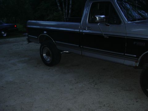 1996 Ford Crown Victoria - A two-tone pickup truck is parked outdoors, with another vehicle visible in the background.