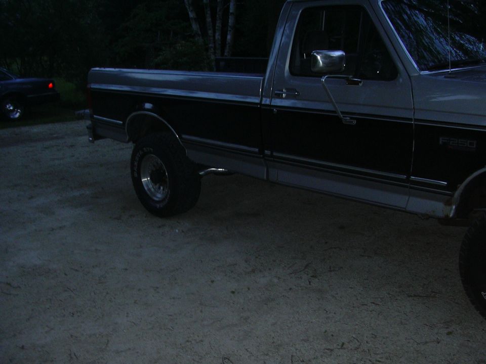 Side view of a two-tone pickup truck, possibly a 1990 Ford F-250