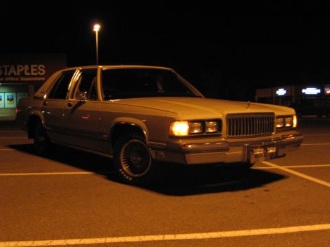 1988 Mercury Grand Marquis - A 1988 Mercury Grand Marquis is parked in a lot at night, illuminated by a street light.
