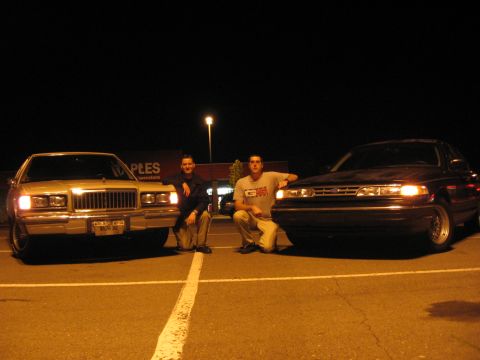 1988 Mercury Grand Marquis - Two men pose with a light-colored 1988 Mercury Grand Marquis and a dark sedan in a parking lot at night.