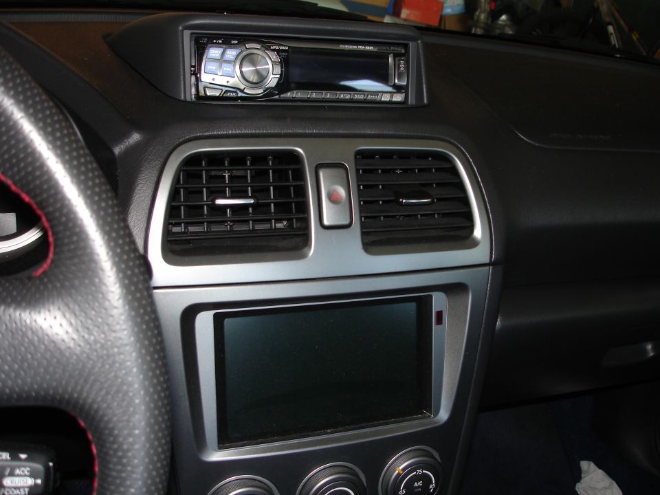 Car dashboard with Alpine head unit, center vents, and lower screen with climate dials.