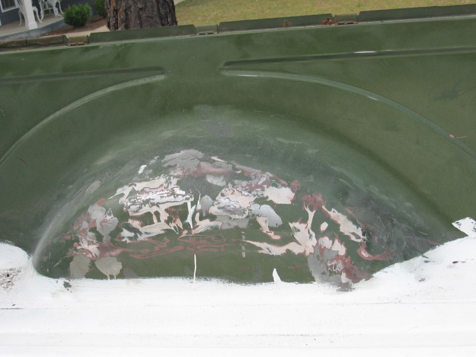 Green 1973 Ford Ranchero wheel well interior with primer and rust patches