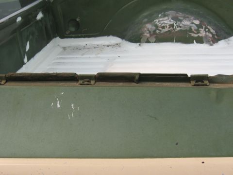 1973 Ford Ranchero - The interior of a truck bed shows sealant application and some wear on the metal surfaces.