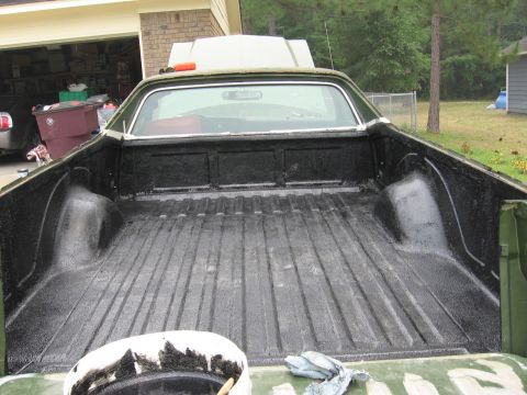1973 Ford Ranchero - The bed of a pickup truck has been coated with a black textured liner material.
