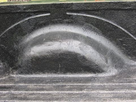 1973 Ford Ranchero - Close-up view of a truck bed liner, highlighting the textured black paint on the wheel well and ribbed floor.