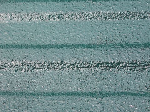 1973 Ford Ranchero - Close-up view of a textured green bedliner with distinct horizontal ridges.