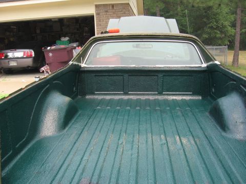 1973 Ford Ranchero - The bed of a 1973 Ford Ranchero, coated in a textured green liner, is shown from a rear-facing perspective.