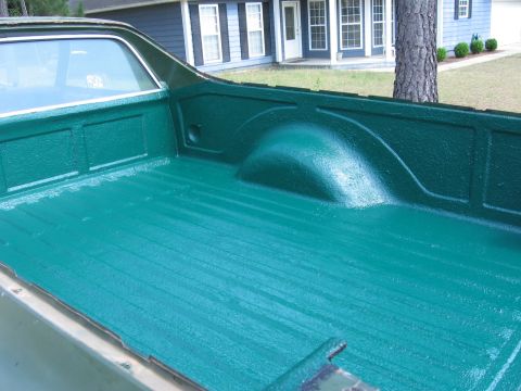 1973 Ford Ranchero - The interior of a truck bed has been coated with a textured green liner.