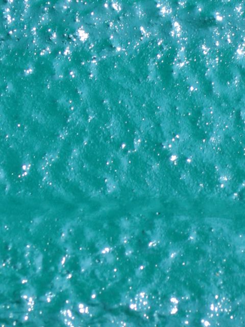 1973 Ford Ranchero - Close-up of a textured teal surface with scattered glitter highlights.