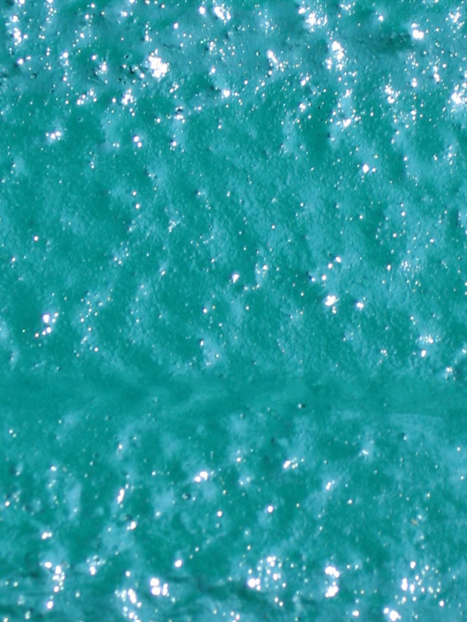 Textured teal surface with small white glitter flecks